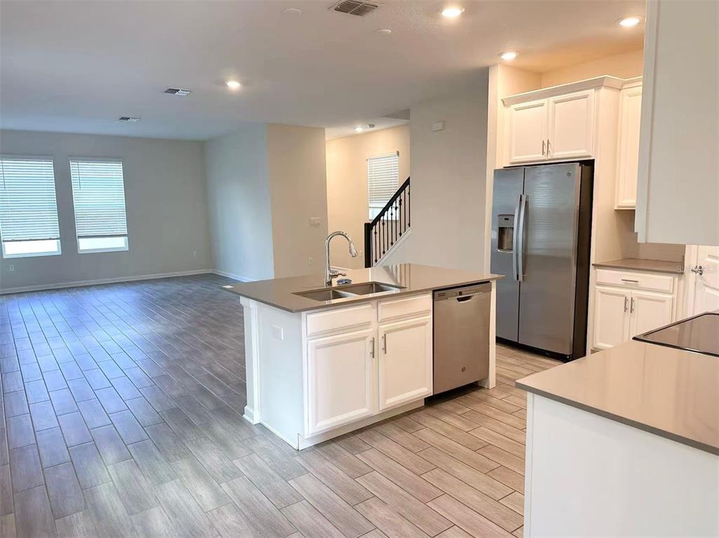 A kitchen with white cabinets, stainless steel appliances, and a central island with a sink — 1374 VISCAYA COVE BOULEVARD, WINTER GARDEN, FL