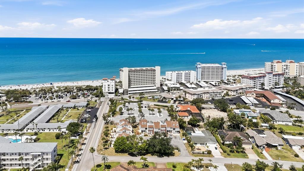 An aerial view shows a beachside resort area with multiple buildings, parking lots, and oceanfront — 744 CADIZ ROAD UNIT 8, VENICE, FL