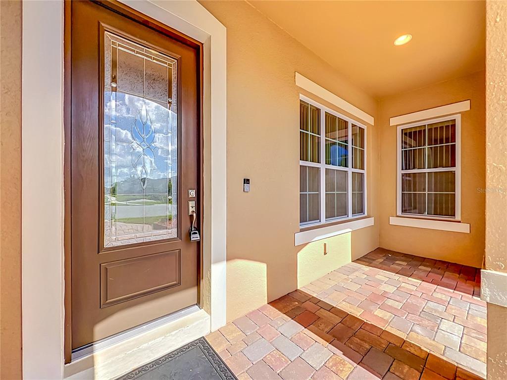 A front entryway features a brown door with a glass insert and a paved porch — 1315 DUSTY PINE DRIVE, APOPKA, FL