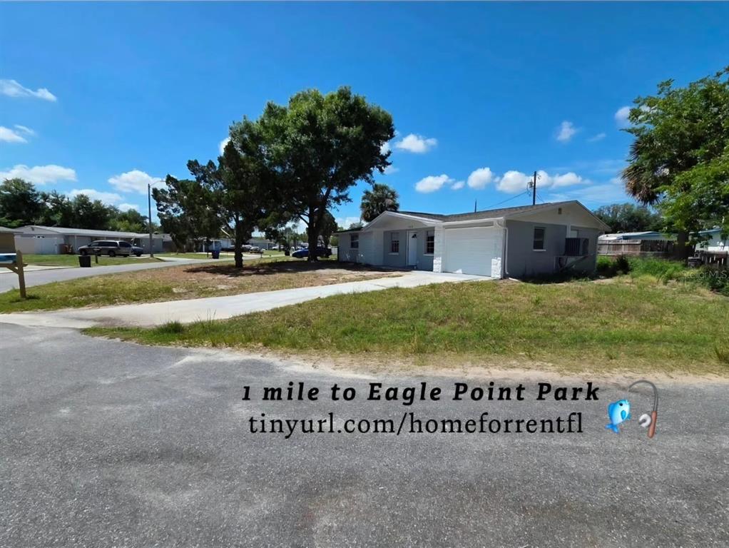 A single-story gray house with a garage sits on a grassy lot with trees — 4616 IRENE LOOP, NEW PORT RICHEY, FL