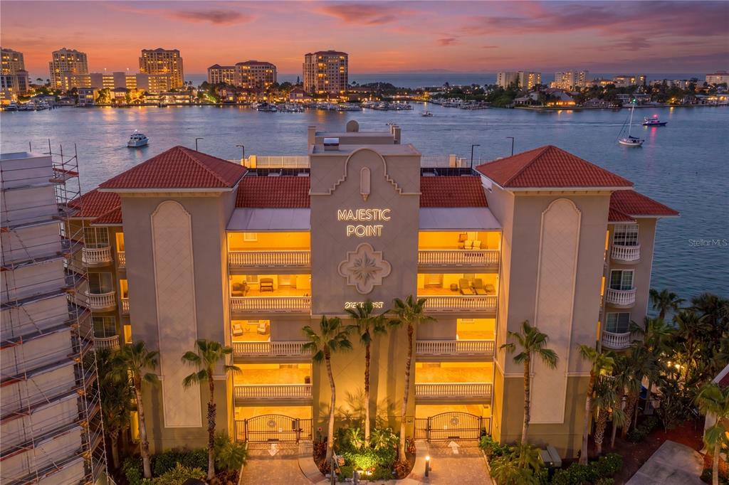 An exterior view of the Majestic Point condominium building at sunset overlooking the water — 200 SKIFF POINT UNIT 501, CLEARWATER BEACH, FL
