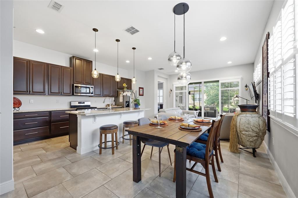 A tan house exterior features a paved driveway, a garage, and a walkway to the entrance — 2486 DATURA LOOP, ST CLOUD, FL