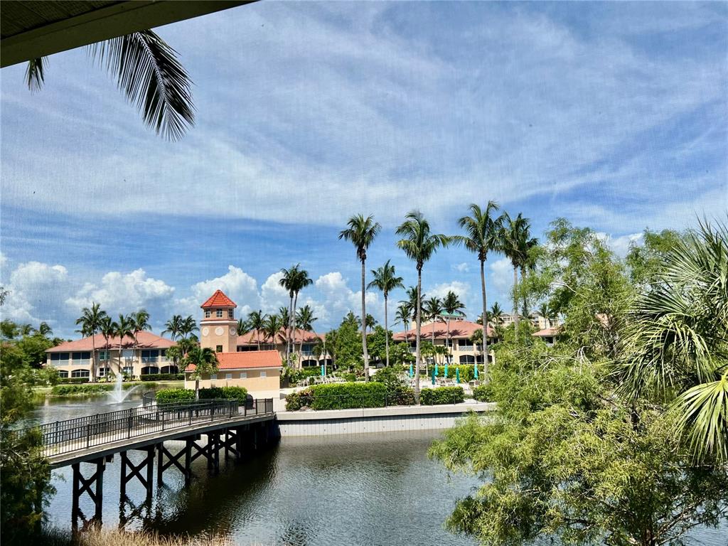 A view of a bridge over a pond leading to buildings with palm trees — 3304 SUNSET KEY CIRCLE UNIT D, PUNTA GORDA, FL