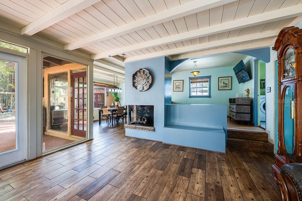 A living room with wood-look tile floors, a blue fireplace wall, and a grandfather clock — 1835 OAK LANE, ORLANDO, FL