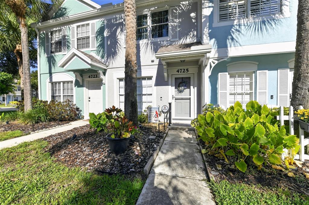 The exterior of two adjacent townhomes features light blue siding, white trim, and concrete walkways — 4725 SABAL KEY DRIVE, BRADENTON, FL