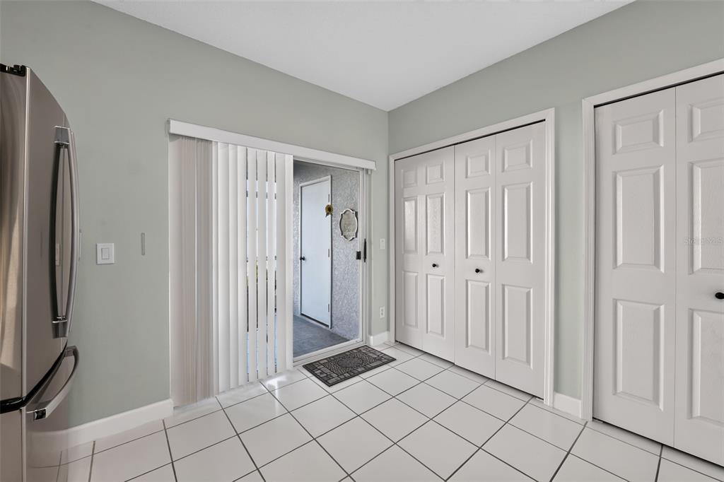 A kitchen area features white tiled floors, a sliding glass door, and two white closets — 4725 SABAL KEY DRIVE, BRADENTON, FL