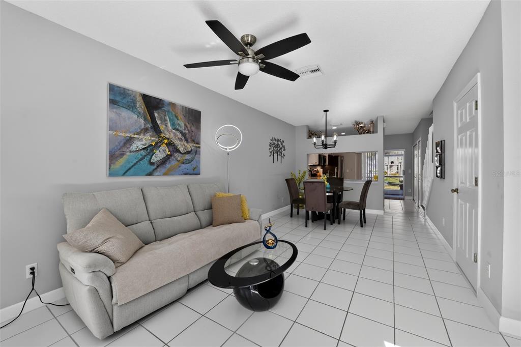 A living room and dining area with light gray walls, tile flooring, and a ceiling fan — 4725 SABAL KEY DRIVE, BRADENTON, FL