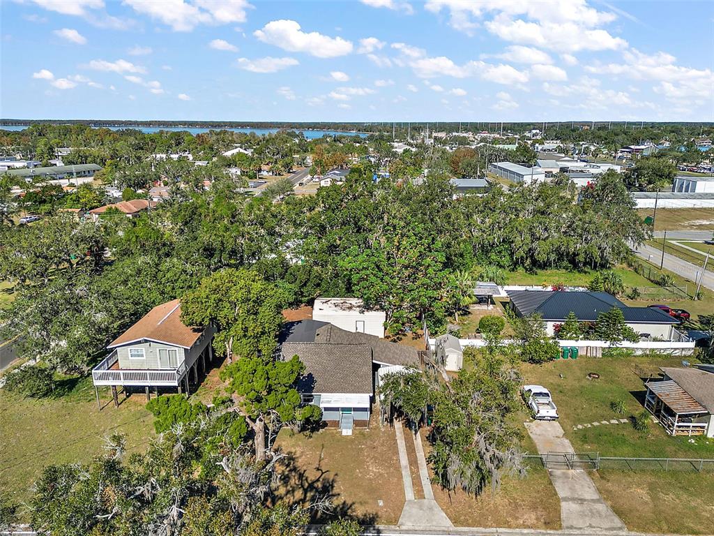 An aerial view shows a residential property with a house, driveway, and surrounding trees — 105 W STEVENS AVENUE, EUSTIS, FL
