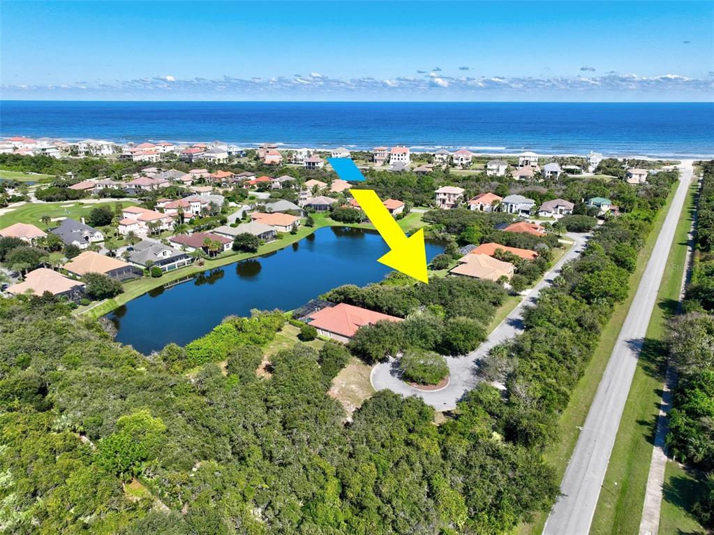 An aerial view shows a house with a red roof situated next to a lake — 40 ATLANTIC PLACE, PALM COAST, FL