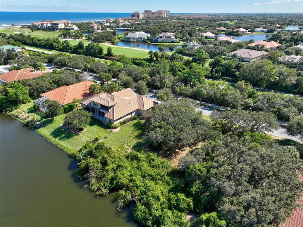 An aerial view shows a house with a tan roof situated beside a lake — 40 ATLANTIC PLACE, PALM COAST, FL