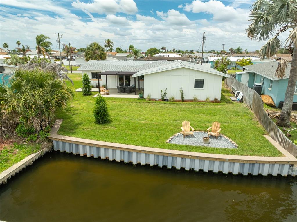 A modern one-story house exterior features white board-and-batten siding, a wood-trimmed window, and a porch — 390 URSA AVENUE, MERRITT ISLAND, FL