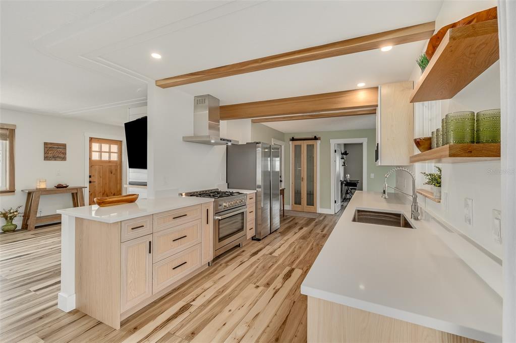 A light green room features a wooden sliding barn door, a white door, and a doorway — 390 URSA AVENUE, MERRITT ISLAND, FL