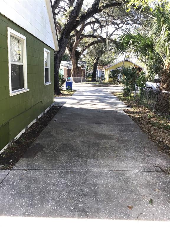 A concrete driveway runs alongside the green exterior wall of a house — 2226 27TH STREET S, ST PETERSBURG, FL