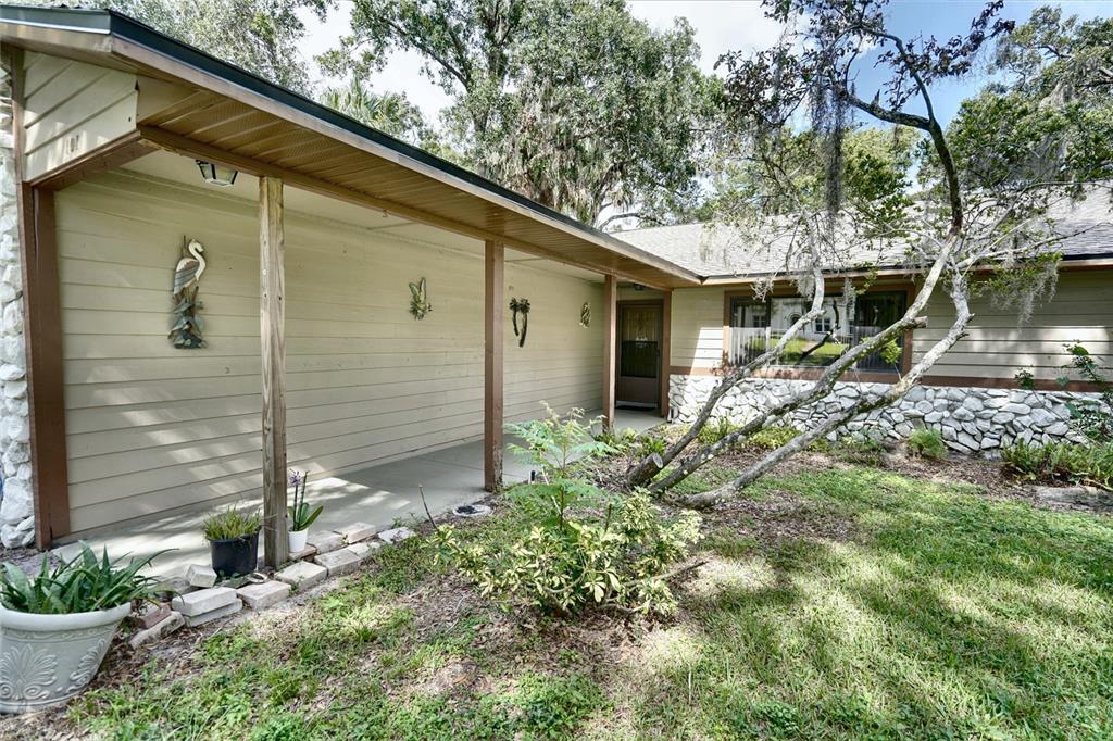 A covered porch with wooden posts leads to the front entrance of a single-story house — 101 N ELLIOTT AVENUE, SANFORD, FL