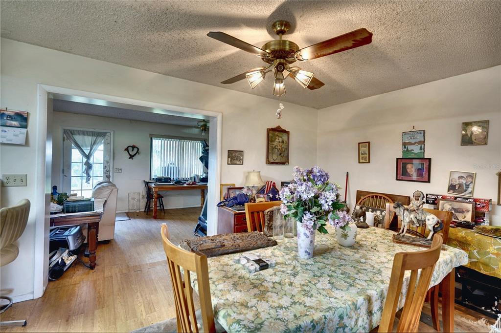 A dining room features a floral tablecloth, a ceiling fan, and an adjacent living area — 101 N ELLIOTT AVENUE, SANFORD, FL