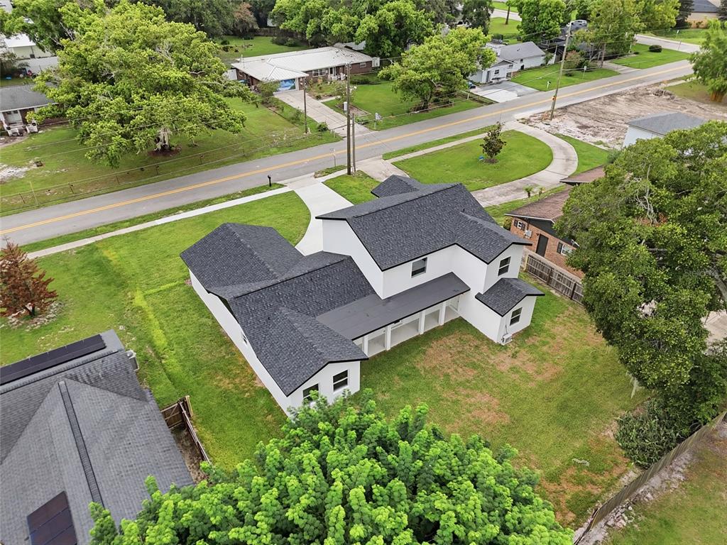 An aerial view shows a white two-story house with a dark shingled roof and yard — 351 E WILDMERE AVENUE, LONGWOOD, FL