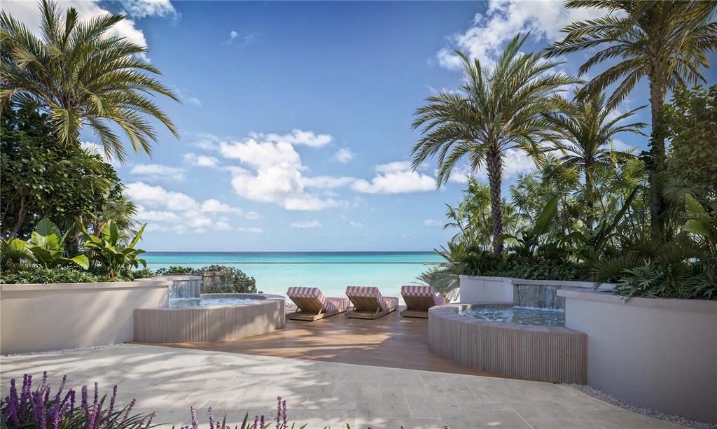 A patio features two circular hot tubs, lounge chairs, and palm trees overlooking the ocean — 805 S GULFVIEW BOULEVARD UNIT 401B, CLEARWATER BEACH, FL