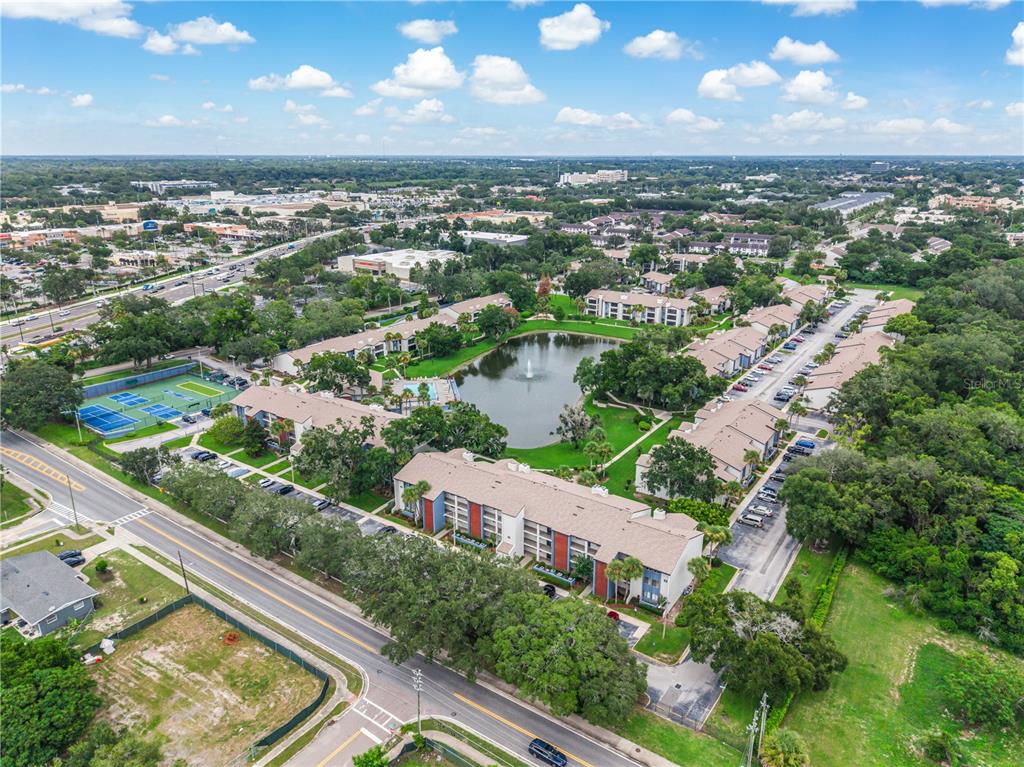 An aerial view shows a multi-building apartment complex surrounding a central pond and tennis courts — 4 ESCONDIDO CIRCLE UNIT 28, ALTAMONTE SPRINGS, FL