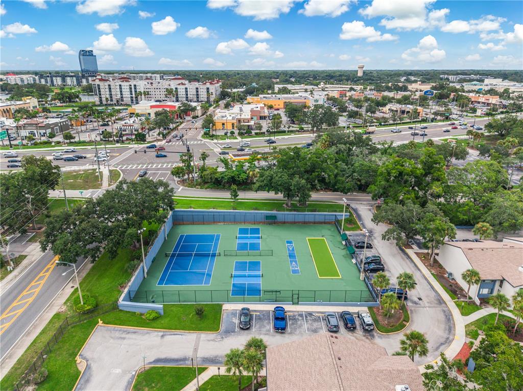 An aerial view shows a tennis court and pickleball courts next to a parking lot — 4 ESCONDIDO CIRCLE UNIT 28, ALTAMONTE SPRINGS, FL
