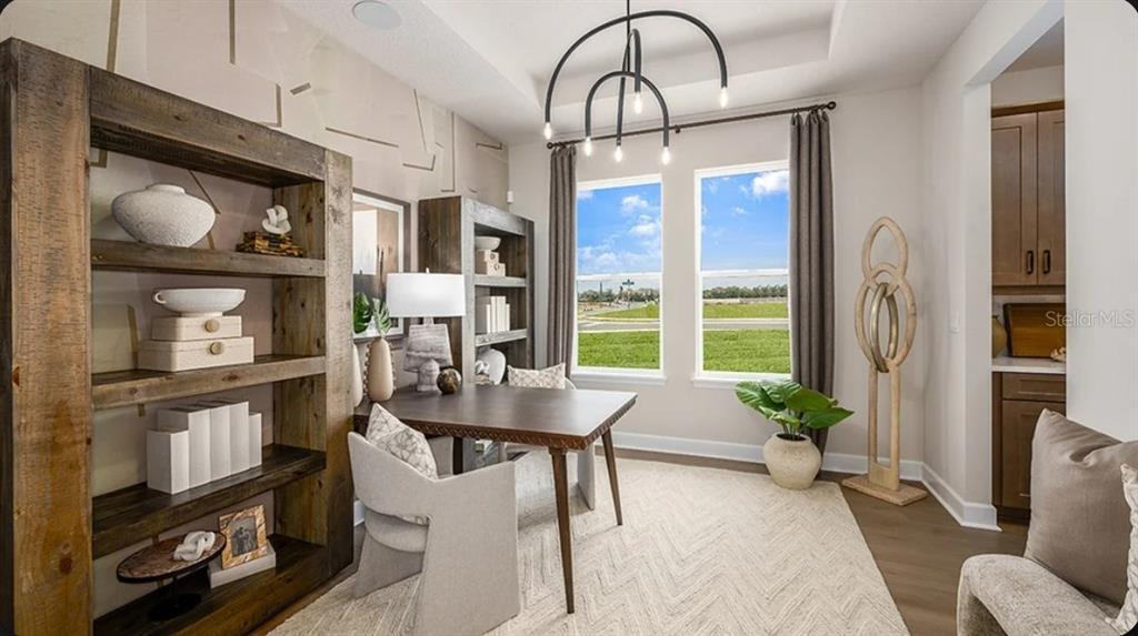 A living room with two beige sofas, a coffee table, and a large sliding glass door — 11783 RALLY RANGE WAY, SAN ANTONIO, FL