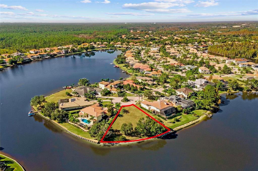 An aerial view shows a vacant waterfront lot outlined in red within a residential community — 17903 BIMINI ISLE COURT, TAMPA, FL