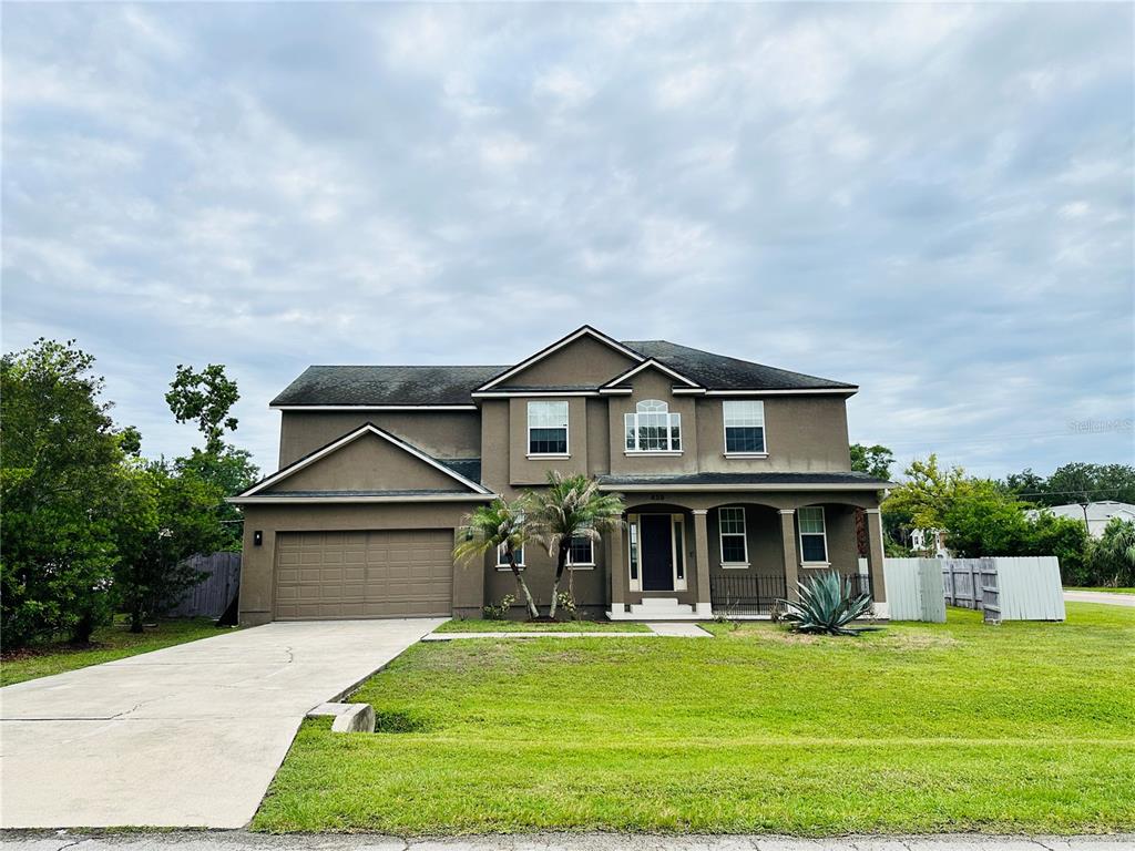 A two-story house with a brown stucco exterior, a two-car garage, and a front porch — 438 PALM DRIVE, SANFORD, FL