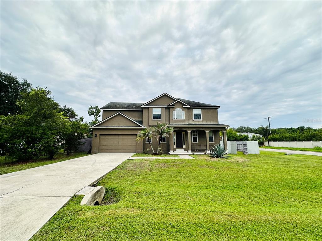 A two-story house with a brown stucco exterior, a two-car garage, and a concrete driveway — 438 PALM DRIVE, SANFORD, FL