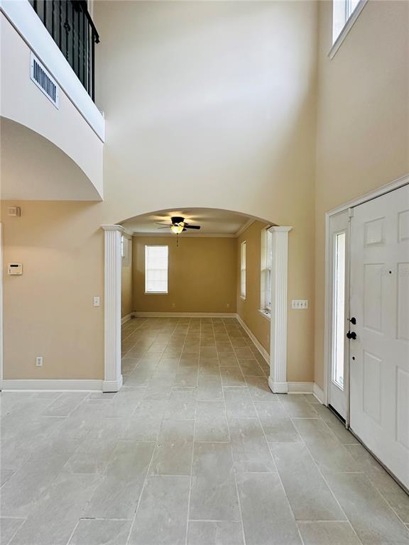 An entryway with tile flooring leads through an arched opening into a living area — 438 PALM DRIVE, SANFORD, FL