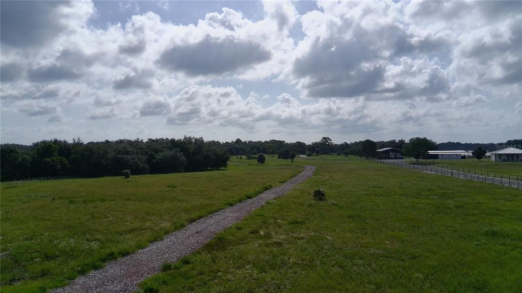 A gravel path winds through a large, grassy field toward distant trees and buildings — 4557 GLEN SAINT MARY ROAD, LAKE WALES, FL