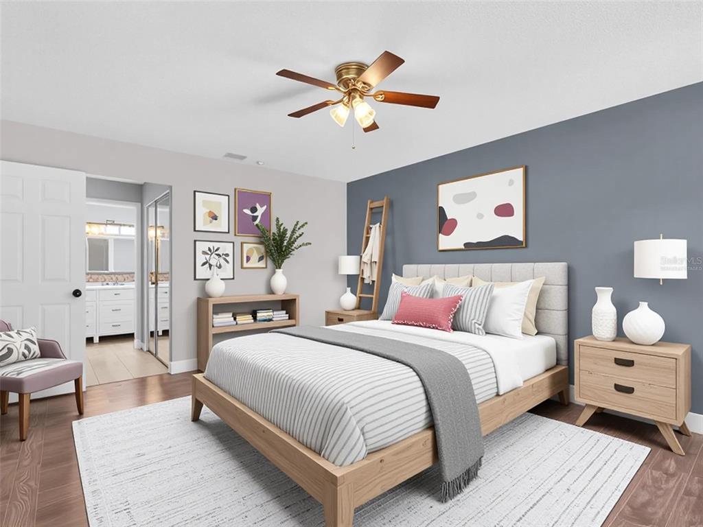 A bedroom features a bed with striped bedding, a blue accent wall, and a ceiling fan — 1801 E LAKE ROAD UNIT 20C, PALM HARBOR, FL
