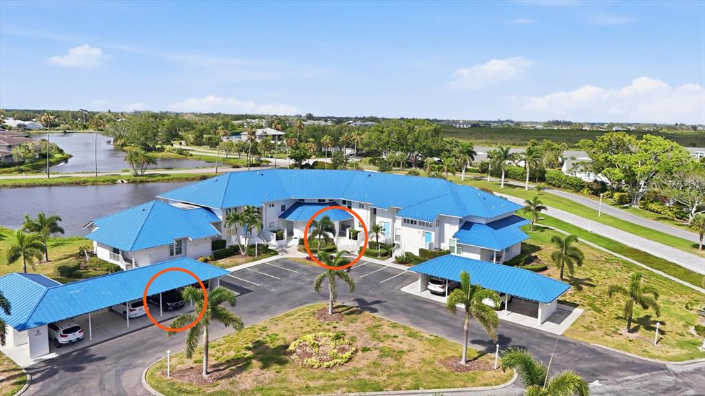 An aerial view of a multi-unit building with blue metal roofs and covered parking — 879 AUDUBON DRIVE UNIT 879, BRADENTON, FL