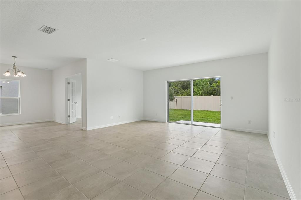 A kitchen features white cabinets, dark countertops, a stainless steel microwave, and a center island — 1349 SAWGRASS HAMMOCK LANE, DAVENPORT, FL