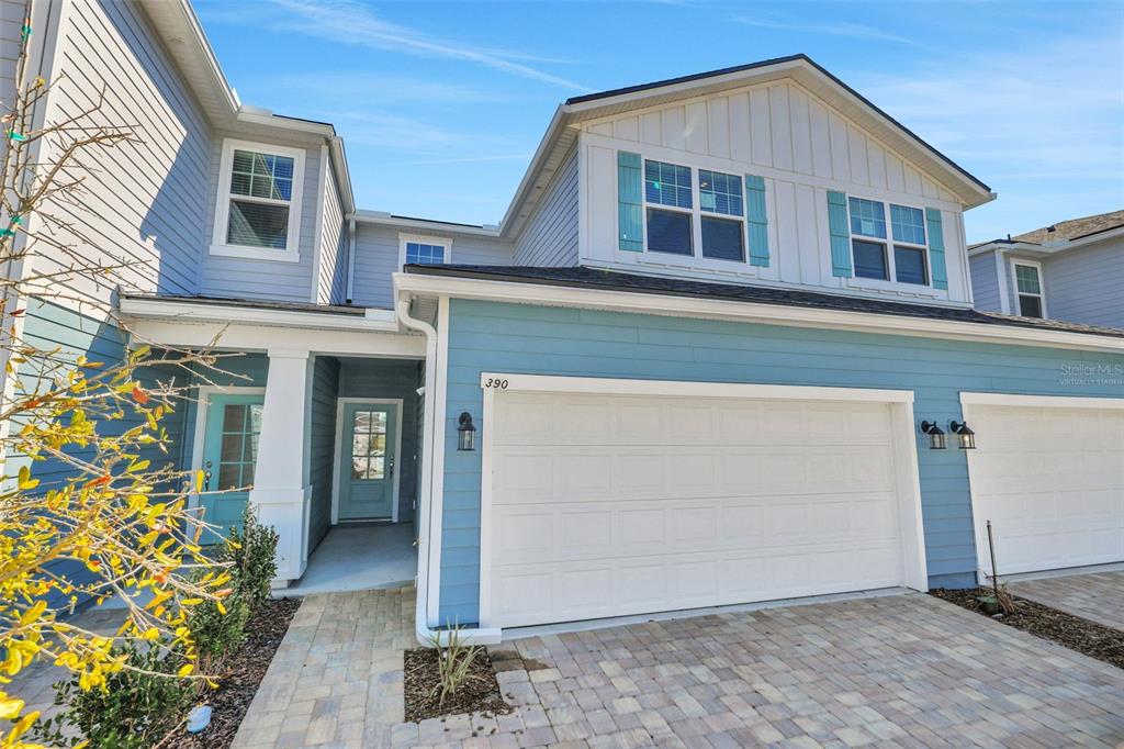 A two-story house with light blue siding, a two-car garage, and a paved driveway — 357 WOODS LANE, ST AUGUSTINE, FL