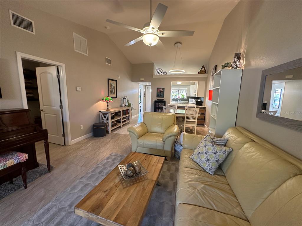 A dining area with a round table and chairs sits adjacent to an open kitchen — 5480 BRASSY LOOP, NORTH PORT, FL