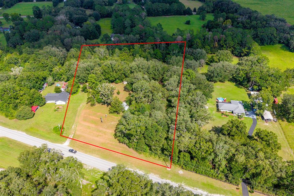 An aerial view shows a rectangular plot of land outlined in red near a road — 5301 NW COUNTY ROAD 235, ALACHUA, FL