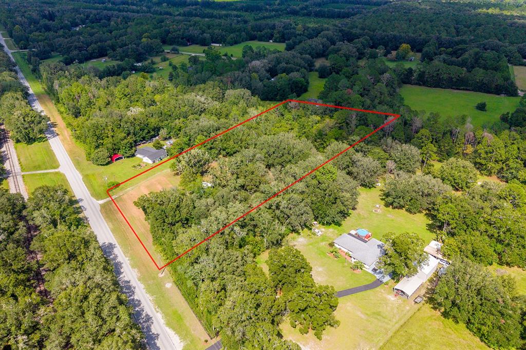 An aerial view shows a rectangular plot of land outlined in red near a road — 5301 NW COUNTY ROAD 235, ALACHUA, FL