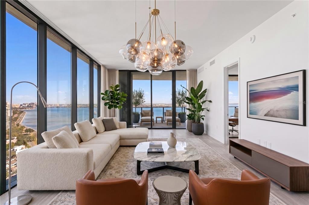 A modern living room features floor-to-ceiling windows with panoramic water and city views — 3015 S YSABELLA AVENUE UNIT 2301, TAMPA, FL
