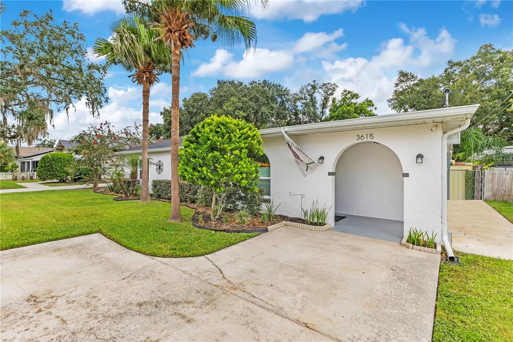 A single-story house with white stucco walls, black shutters, and two palm trees in front — 3615 S SUMMERLIN AVENUE, ORLANDO, FL