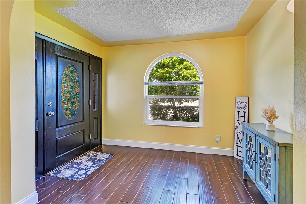 A backyard features a swimming pool with a concrete deck, a hedge, and large trees — 3615 S SUMMERLIN AVENUE, ORLANDO, FL