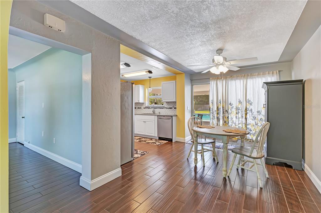 A white single-story house with a concrete driveway, arched entryway, and palm trees in front — 3615 S SUMMERLIN AVENUE, ORLANDO, FL