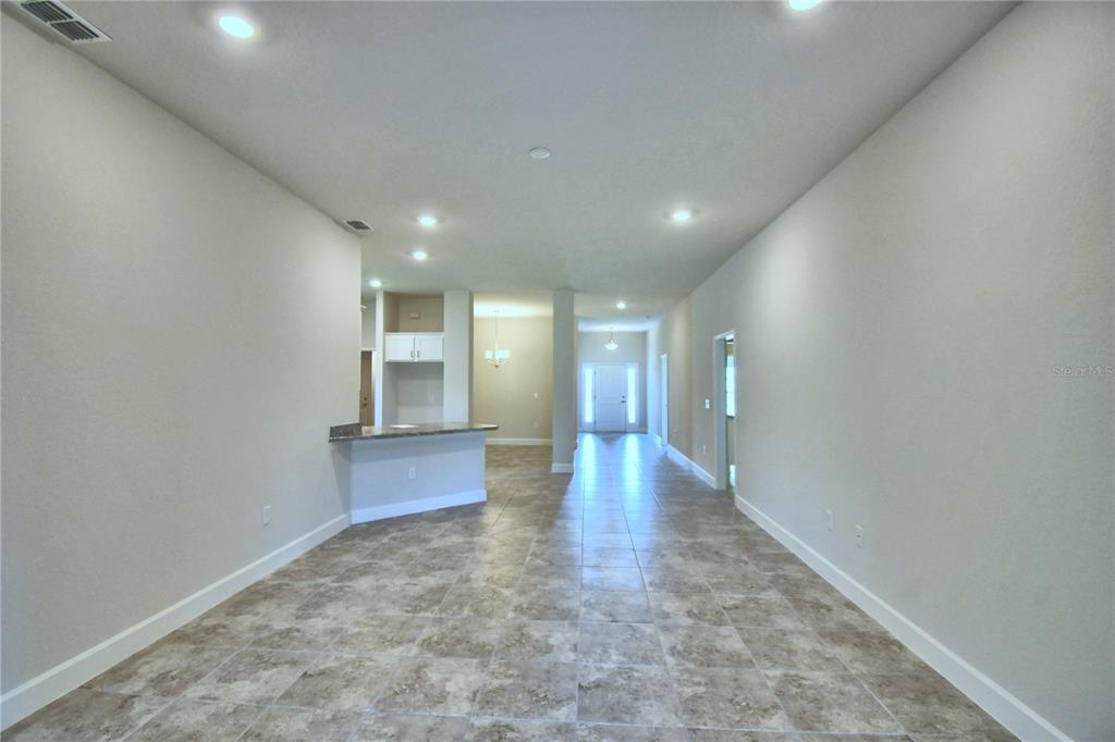 An open-concept living area features light-colored walls, recessed lighting, and neutral tile flooring — 4632 CALAMINT LANE, AUBURNDALE, FL