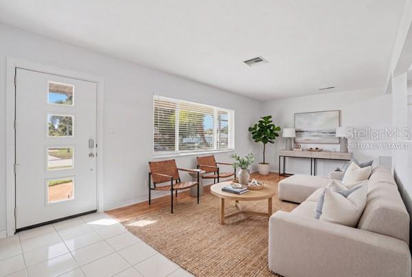 A living room features a white front door, a beige sectional sofa, and two armchairs — 5091 35TH TERRACE N, ST PETERSBURG, FL