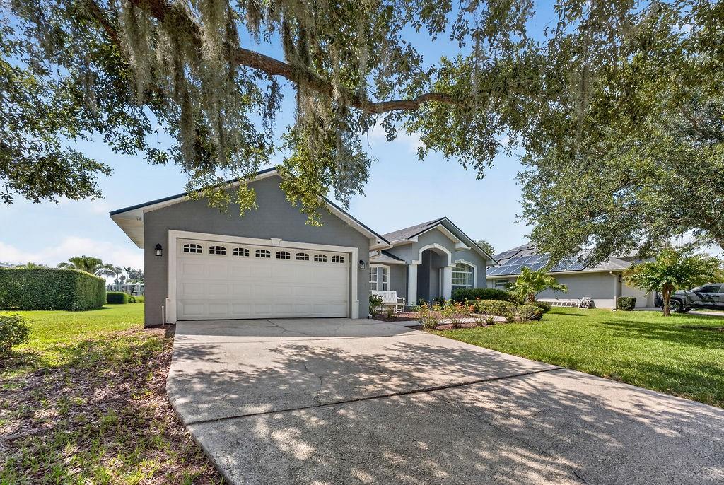 A covered patio features a dining set, a ceiling fan, and large windows overlooking a lake — 118 RACHEL LIN LANE, ST CLOUD, FL