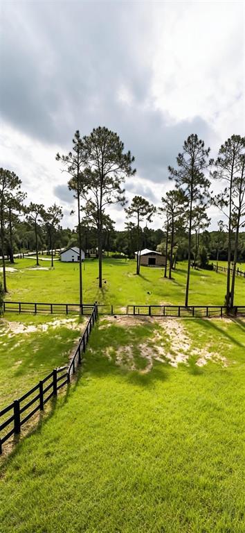 An aerial view shows a grassy pasture with black fencing and two small outbuildings — 11670 SE 55TH LANE, MORRISTON, FL