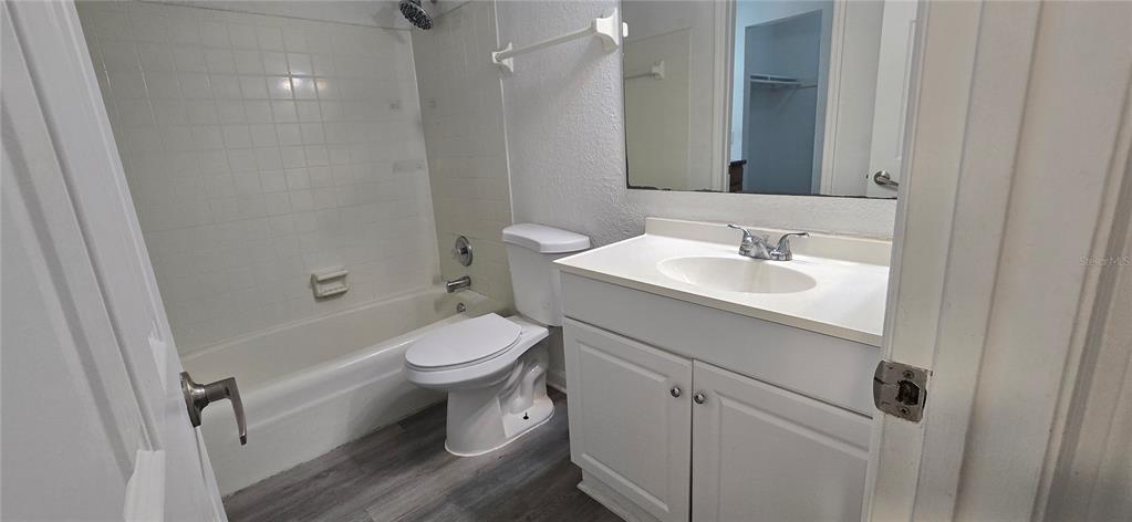 A bathroom featuring a white vanity, a toilet, and a shower-tub combination with white tiles — 8849 S OLD KINGS RD UNIT 143, JACKSONVILLE, FL