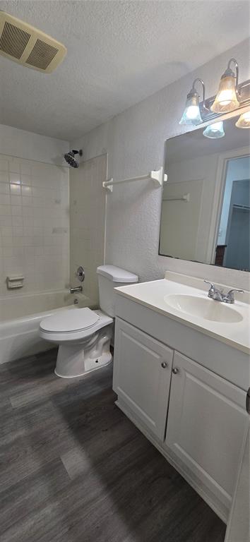 A bathroom with a white vanity, toilet, and a shower-tub combination with gray wood-look flooring — 8849 S OLD KINGS RD UNIT 143, JACKSONVILLE, FL