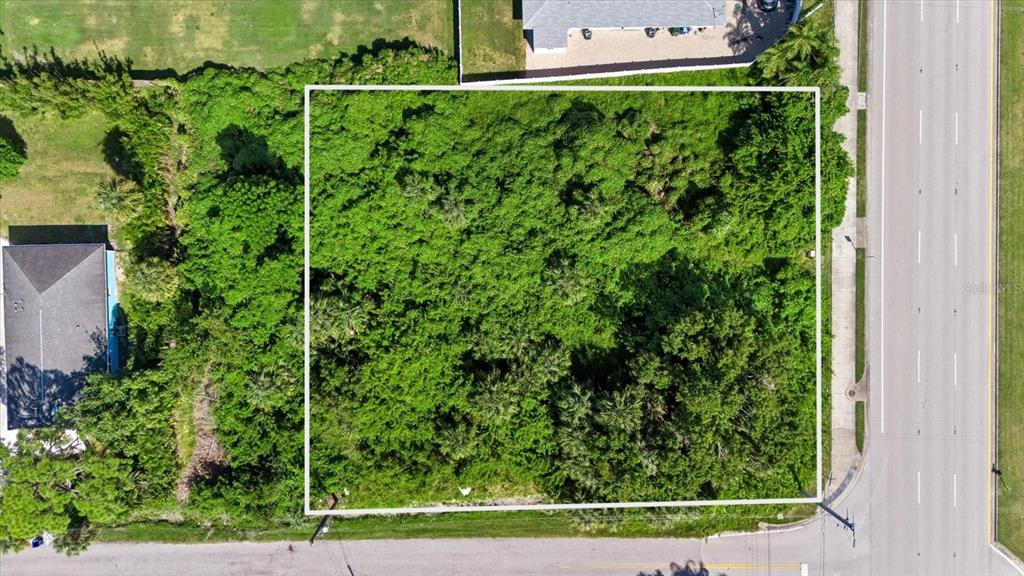An aerial view shows a rectangular, tree-covered vacant lot bordered by a road and houses — 0 LA PALMA, NOKOMIS, FL