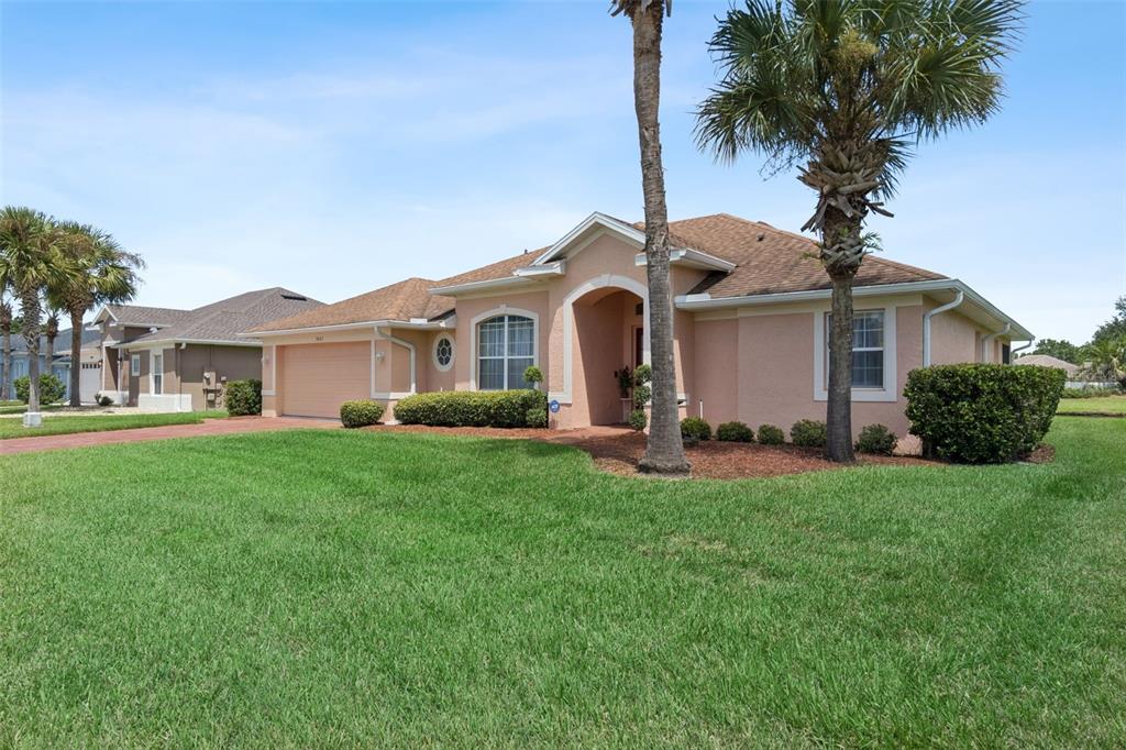 A single-story peach-colored house with a two-car garage and palm trees in the front yard — 3805 LAUREL VIEW DRIVE, KISSIMMEE, FL