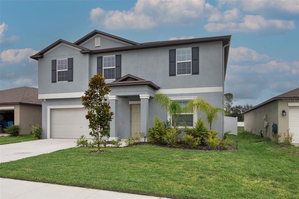 A two-story gray house with a two-car garage and a small front yard — 11693 LAVENDER LOOP, SPRING HILL, FL