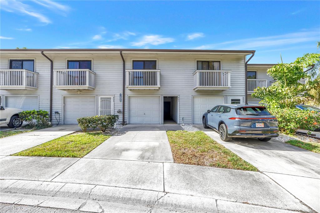 A white picket fence sign for Lake Forest stands outdoors surrounded by trees and bushes — 6462 92ND PLACE N UNIT 803, PINELLAS PARK, FL